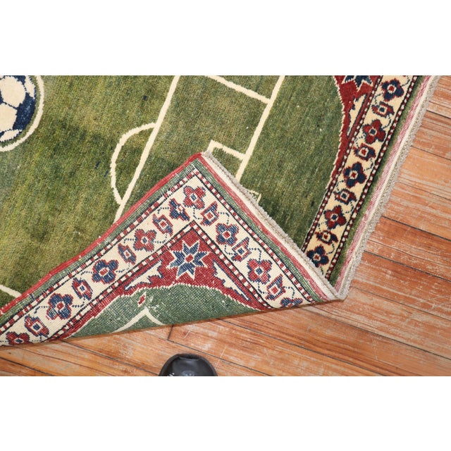 One of a kind hand-knotted 100 % vegetable-dyed rug depicting a soccer field surrounded by a traditional border. Measures:...
