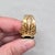 1960s goldtone wide band with prong oval faux-emerald with filigree detail surround adjustable ring. Marked "NAPIER©" on...