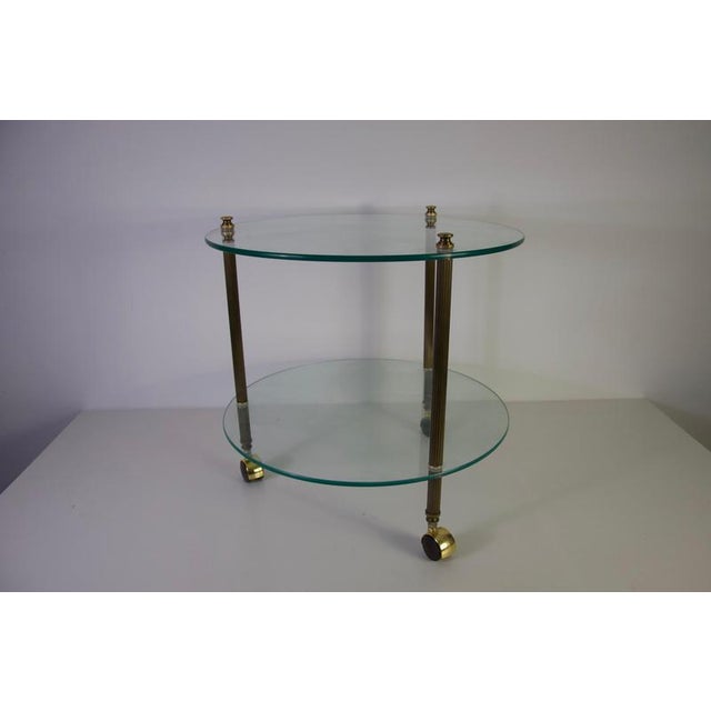 French brass and glass bar cart, France, 1950s. This elegant vintage drinks trolley features two circular clear glass...