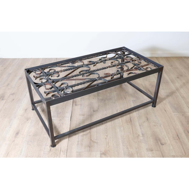 This unique coffee table repurposes antique French balcony railings into a striking piece of functional art. The tabletop...