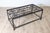 This unique coffee table repurposes antique French balcony railings into a striking piece of functional art. The tabletop...