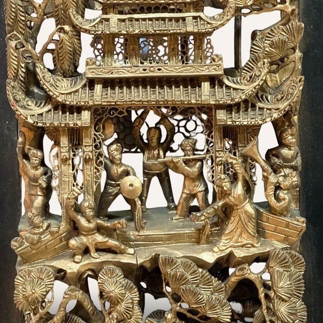 This Chinese carved wood panel from the first half of the 20th century features a cavalry, musicians and building motif....