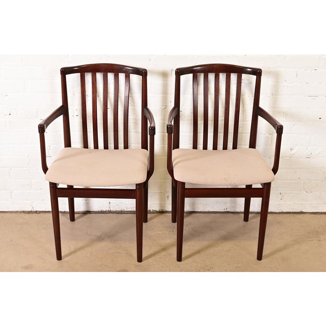 A sleek and stylish pair of mid-century Danish Modern sculpted rosewood armchairs or dining captain chairs By Vamdrup...