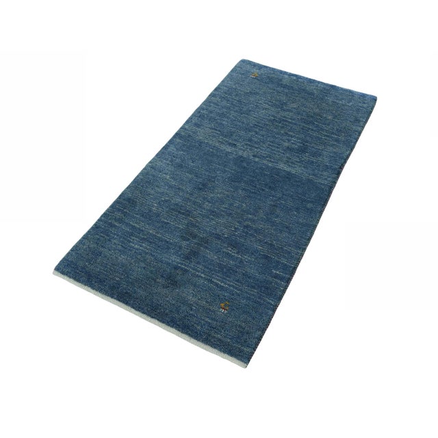 This hand-knotted Gabbeh Loribaft rug impresses with its modern minimalism and traditional craftsmanship. The calm,...