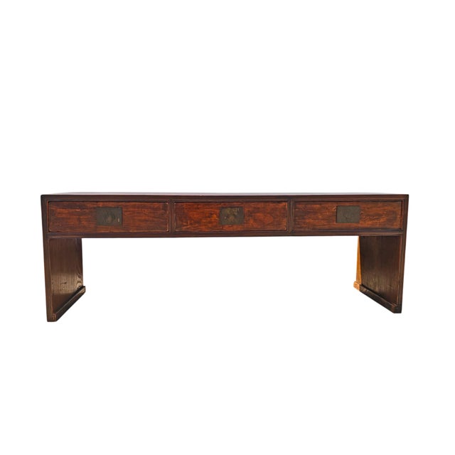 This antique 20th century low table is a traditional three-drawer coffee table handcrafted from solid elm wood from the...