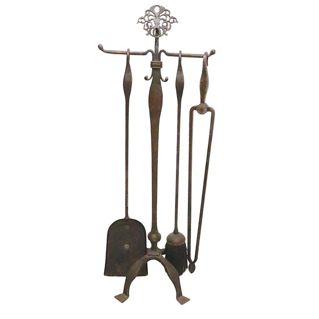 Exceptional four piece fireplace tool set constructed of hand wrought iron, with a decorative cast brass filigree...
