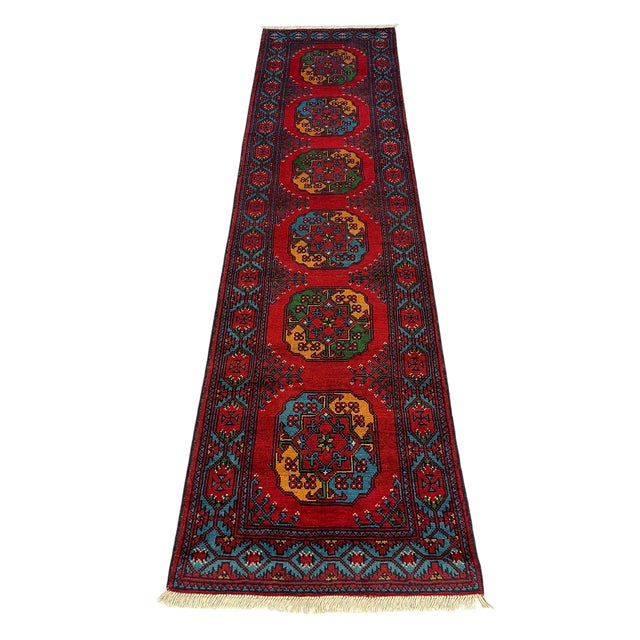 This wool runner features six colorful geometric medallions against a rich red field. Turquoise blue, green, and golden...