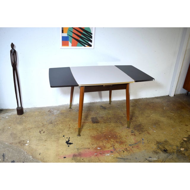 This is a multifunctional vintage table from the 1960s. The height can be adjusted using a crank. The table is extendable....