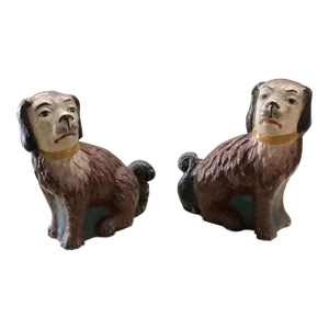 A Pair of Mid 20th Century British Colonial Seated Burgundy & White Dogs