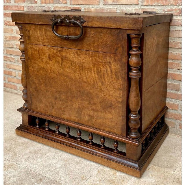 Antique solid wood chest featuring a strong architectural presence, with turned side columns, a paneled front, and an...