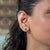 Matched round Zambian emeralds in a martini-set 14K gold stud — the setting angles each stone to catch the light. Deep,...