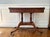 This Duncan Phyfe Style Flip-Top Game Table, circa 1840-1860, features delicate bronze inlay on the apron. The top and...
