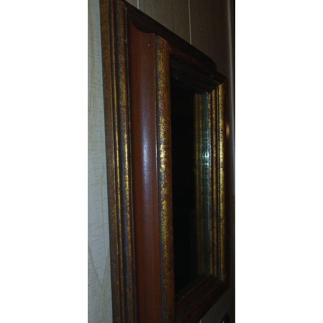 Victorian-style picture frame wall mirror featuring a deep-well design. Wood with gilded finish over a deep dark burgundy....
