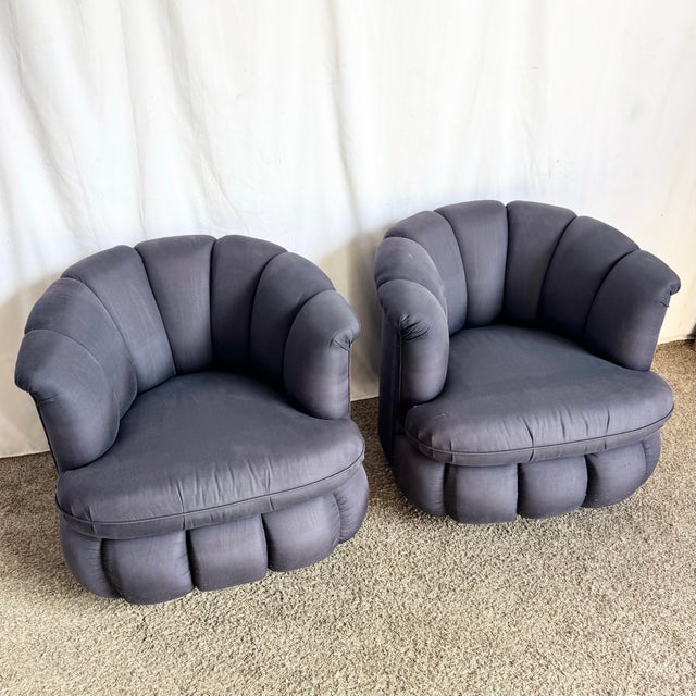 This striking pair of postmodern lounge chairs features sculptural clam shell silhouettes with deeply channel-tufted...