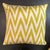 Woven ikat pillow in a soft green/gold chevron pattern on an off-white background. The reverse is velvet with a geometric...