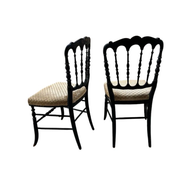 A refined and timeless pair of antique Chiavari dining chairs, featuring the signature slender spindle back and gracefully...
