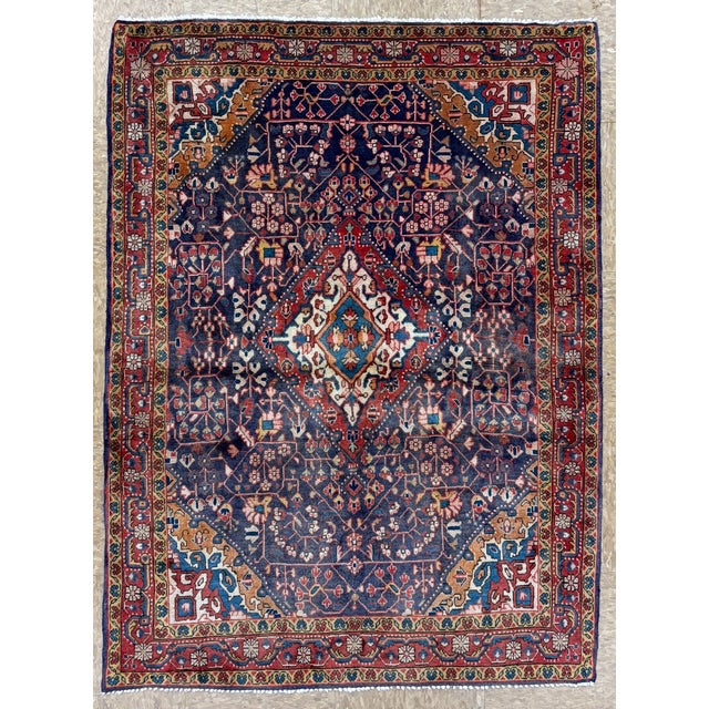 Hand-knotted rug from the Jozan area of western Iran, featuring a central medallion set within a deep indigo field. The...