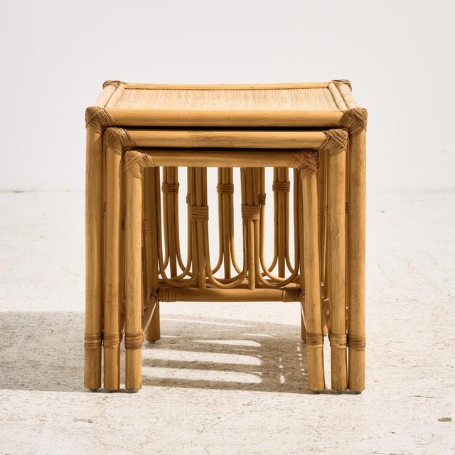 A nesting table from the 1970s made of natural materials. The table consists of three pieces with a bamboo frame and...