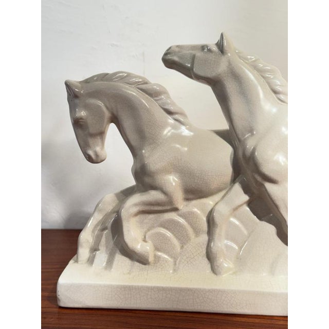 This elegant French Art Deco sculpture features two stylized horses galloping side-by-side on a rectangular base. The...