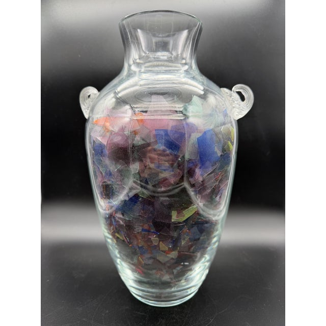 An elegant amphora vase in hand-blown Murano glass created by L'OVC Cenedese. It features a transparent body with two...