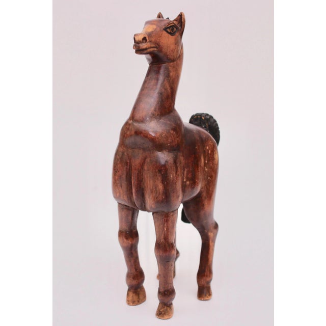 Charmingly striking carved wooden horse would bring style to a wide variety of decors. In excellent vintage condition.