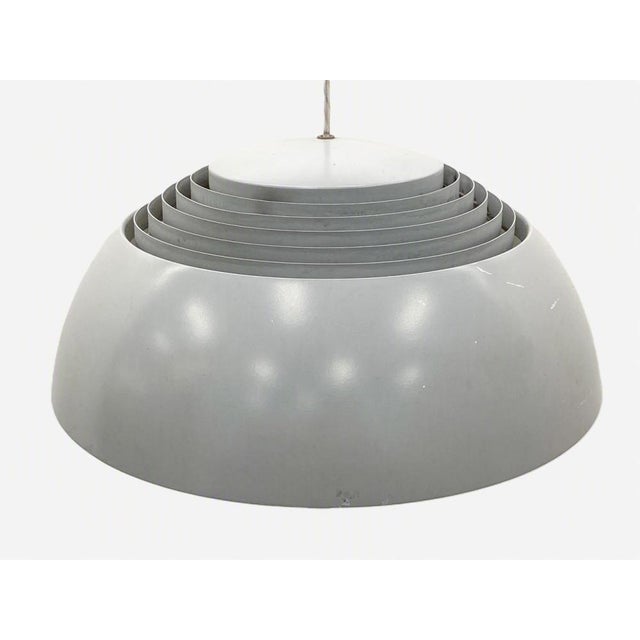An elegant 1970's AJ Royal metal lamp designed by Arne Jacobsen for Louis Poulsen. The aluminum lamp diffuses light...