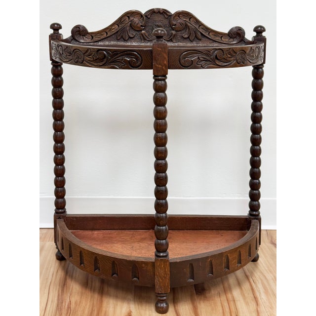 Antique Edwardian style oak bow front umbrella stand. Features intricately floral patterned carved natural wood frame and...