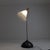 A floor lamp consisting of a hemispherical base and a dark gray painted metal stem. The conical shade is made of white...