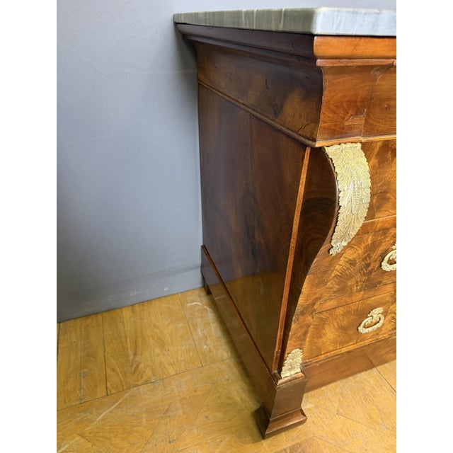 A Restoration period commode, circa 1820, in walnut and walnut veneer. It features four drawers in the front and...