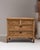This early 20th century French carved chest of drawers from France is made in pale, limed oak with a carved, fronted...