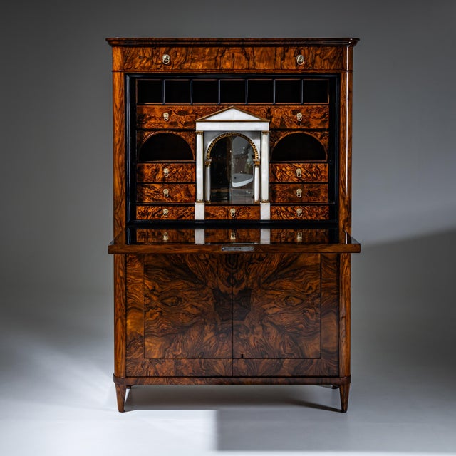 Exceptional Biedermeier secretary in walnut featuring a striking book-matched veneer pattern across the front. The fall-...