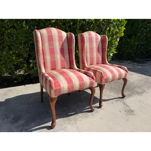 Elegant pair of vintage English-style wingback host chairs upholstered in a distinctive coral, pink, cream, and green...