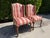 Elegant pair of vintage English-style wingback host chairs upholstered in a distinctive coral, pink, cream, and green...