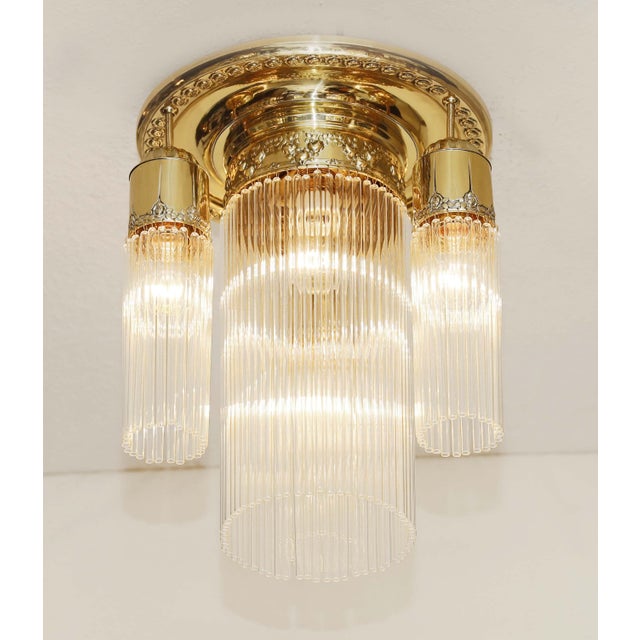 Art Nouveau brass lamp, circa 1915. Large brass ceiling plate with floral embossing. Cylindrical brass sockets suspended...