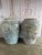 An exceptional pair of oversized rustic terracotta amphora vessels featuring a beautifully weathered surface with organic...