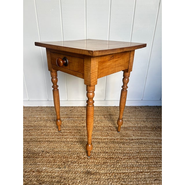 A striking 19thmcentury American side table crafted from richly figured tiger maple. This petite piece features a single...