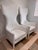Dramatic pair of 1990s high back lounge chairs with a sculptural, flared silhouette and clean white painted frames. The...