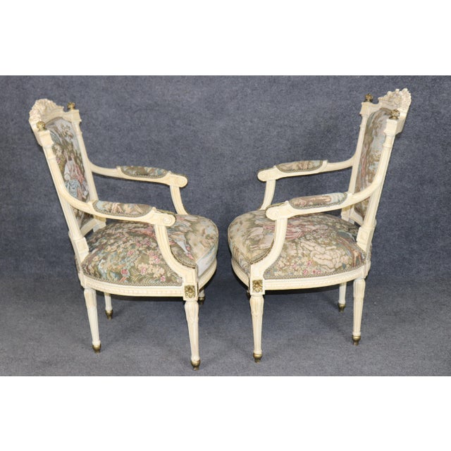 This elegant pair of French Louis XVI-style fauteuils, dating to the early twentieth century, circa 1900–1920, displays...