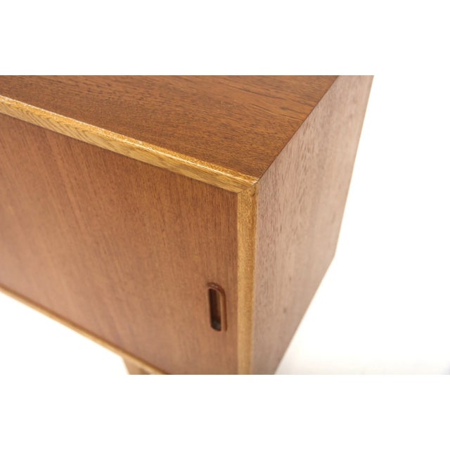 Vintage Scandinavian sideboard, 1960s. Teak frame with contrasting oak surround. Two sliding doors with recessed handles,...