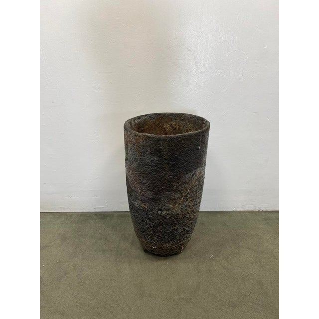 Tall outdoor stone planter reminiscent of an antique industrial crucible. Natural patina. Dimensions:17" D x 30" H