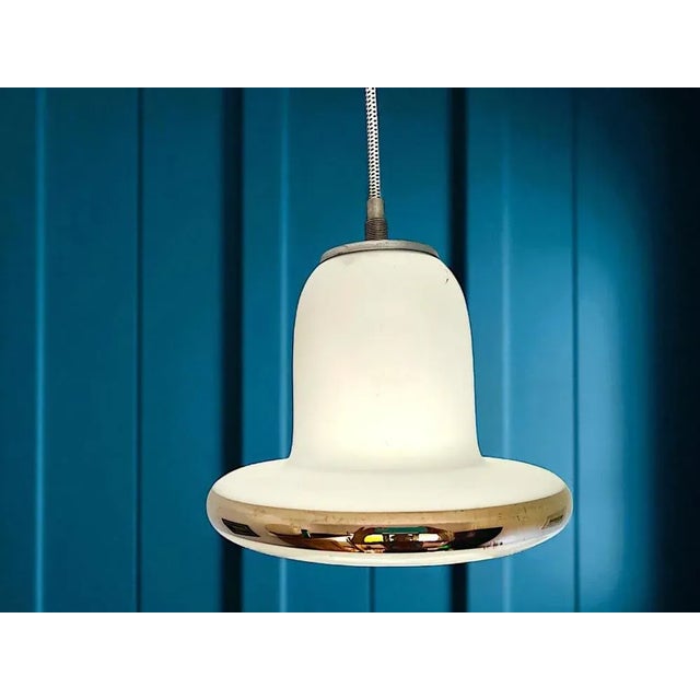 Scandinavian mid-century modern pendant lamp. Material: The shade is made of white opal glass with a silver stripe; the...