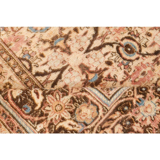 An early 20th century Persian Meshad (Meshed) antique rug, the camel field with a lattice overall of palmettes, feathery...