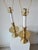 This lamp features a simple design. It has a sturdy brass base with a round, flat plate above the base and a cylindrical...