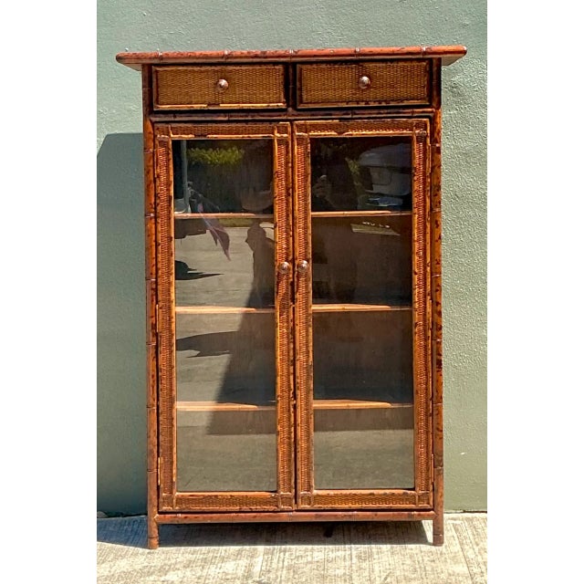 Crafted from tortoise-finished bamboo, this vintage cabinet showcases classic late 19th-century organic craftsmanship. The...