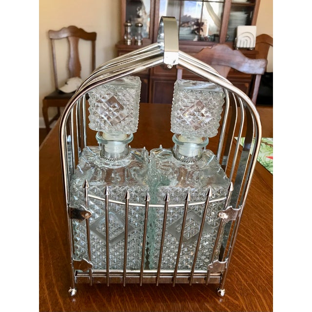 Mid-Century Modern Barware Chrome Caddy with Pressed Glass Liquor Bottles. The bottles have metal labels of ‘Scotch’ and...