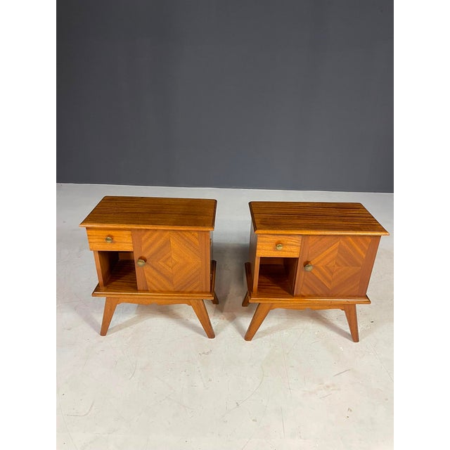 These vintage wooden nightstands feature a clean, understated design characteristic of mid-century modern furniture. The...