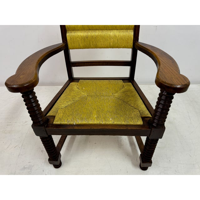 Armchair by Charles Dudouyt This armchair has a sturdy, rustic design with intricate craftsmanship. The frame is made of...