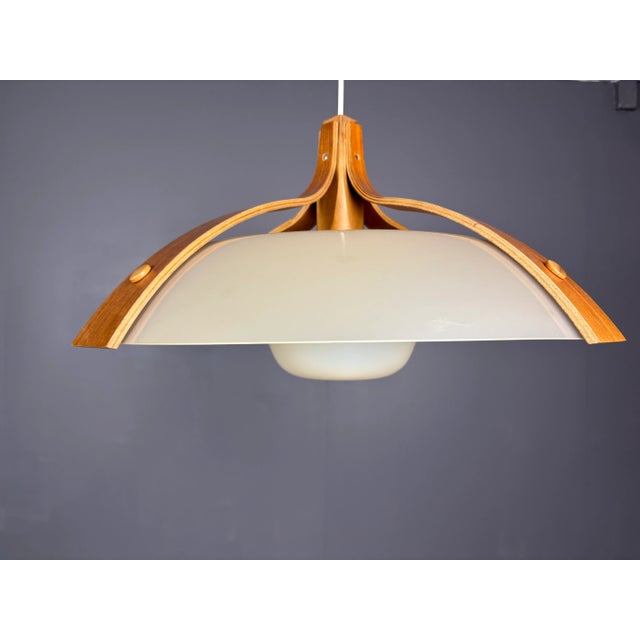 Rare pair by temde, model '328' in layered walnut and moulded plastic, switzerland 1960s a sleek, space age pendant lamp...