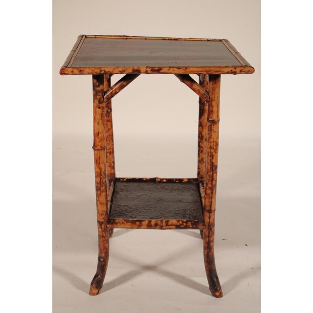 Aesthetic movement bamboo and lacquer side table, circa 1910. With a black and red lacquer top with floral and bird...