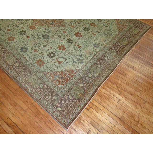 An early 20th century Persian Tabriz rug in earth tones with an autumn-like motif.